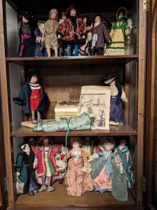 Display of handmade dolls and a newspaper clipping about their make Miss Ena Lynn. 