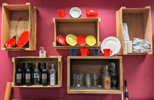 Colorful Display of specialist consumables props for purchase. Including red and yellow plates, sugar glass wine bottles, and pub glasses.