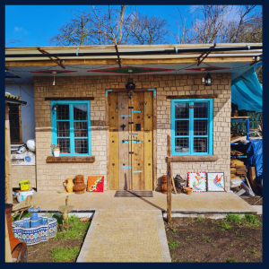 A photograph of the construction of a community art workshops at Plattfields Market Garden in Manchester. The image shows the community project using sustainable materials recycled from Stockyard North.