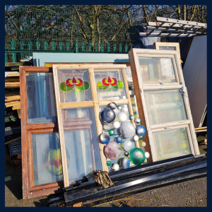 A photograph of reclaimed wooden and stained glass window panels being used at sustainable garden project, Plattfields Market Garden