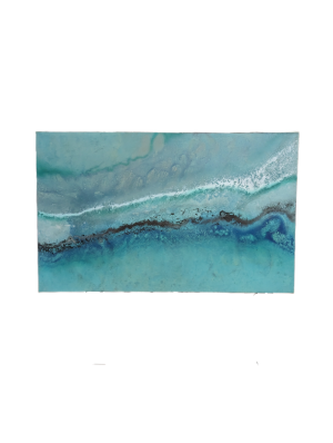 A painting on canvas. A mix of blue paints and white detail creates the impression of gentle waves in the sea.